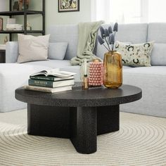 a living room with a couch, coffee table and books on top of the tables