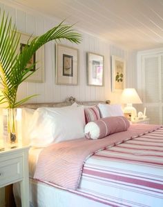 a bed room with a neatly made bed and pictures on the wall next to it