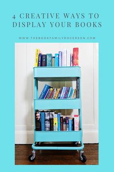 a blue cart with books on it in front of a white wall and wooden floor