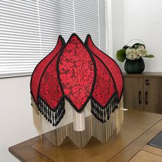 a red and black decorative object sitting on top of a wooden table