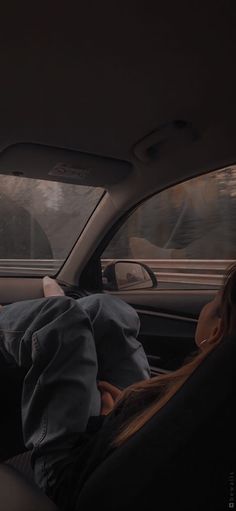 two people sitting in the back seat of a car, one is holding his head