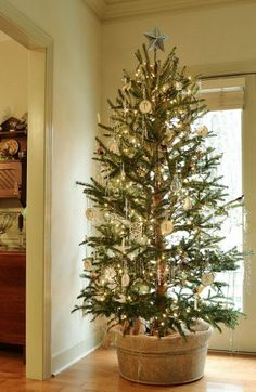 a small christmas tree in a pot on the floor