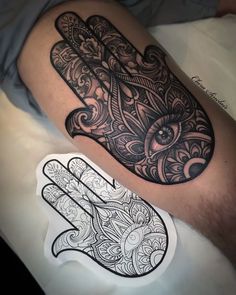 a black and white hamsa tattoo on the leg