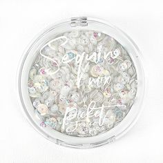 a round container filled with lots of different types of buttons and writing on the lid