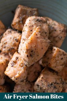 a close up of food in a bowl with the words air fryer salmon bites