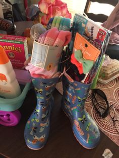 a pair of rubber rain boots sitting on top of a table filled with baby items