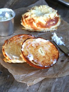 some food is sitting on a piece of wax paper next to a cup and knife