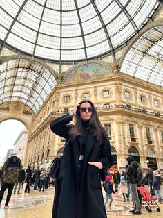 a woman is standing in the middle of a building