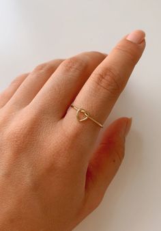 ❤︎ MATERIALS 14k Gold Filled ❤︎ SIZE Band is approximately 1mm thick ❤︎ What is Gold Filled? These 14k Gold Filled rings consists of 5% (1/20) solid gold pressure bonded over brass. They are tarnish resistant and are perfect for those with allergies or sensitive skin. Gold-filled jewelry has 100x more gold alloy than gold plated and because that layer is so much thicker, it means gold-filled jewelry lasts longer and stands up to wear and tear better than gold plated. As long as the piece is well Dainty Valentine's Day Stackable Heart Ring, Dainty Adjustable Stackable Heart Ring, Dainty Heart-shaped Stackable Rings As Gift, Minimalist Stackable 14k Gold Heart Ring, Minimalist Adjustable Yellow Gold Heart Ring, Heart Knot Ring, Heart Knot, Love Knot Ring, Layered Rings