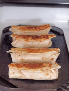 three quesadillas sitting on top of an oven