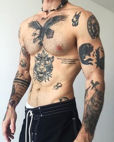 a shirtless man with tattoos on his chest and arm is posing for the camera