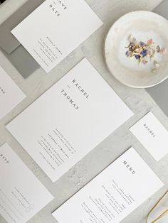 the wedding stationery is laid out on top of the table