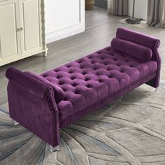 a purple couch sitting on top of a rug