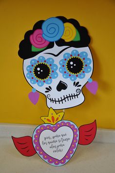 a paper cut out of a skeleton holding a heart with flowers on it's head