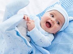 a baby laying on top of a blue blanket