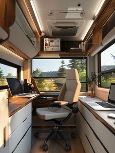 the interior of an rv with a desk, laptop and chair in front of it