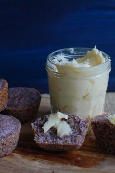 there are some muffins on the table next to a jar of cream cheese