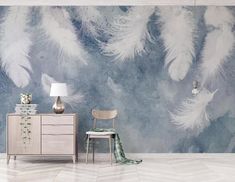 a room with a chair, table and wallpaper that has white feathers on it