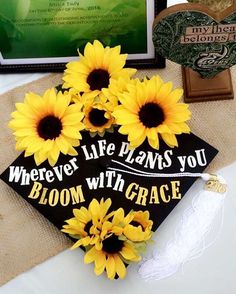 a graduation cap with sunflowers on it sitting next to other decorations and books