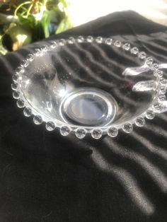 a clear glass bowl sitting on top of a black cloth