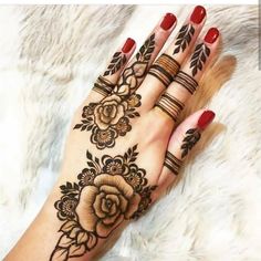 a woman's hand with henna tattoos on it