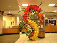 a bunch of balloons that are in the shape of a dragon on a pole at an airport