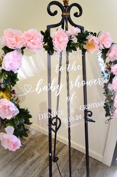 a wedding arch with pink flowers and greenery