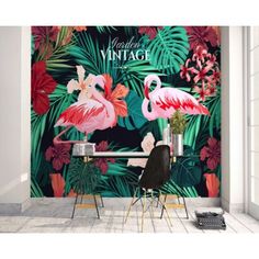 two pink flamingos are standing in front of a wall mural with tropical leaves and flowers