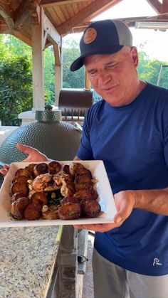 a man holding a plate with food on it