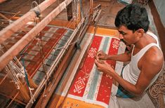 a man is working on an intricate weaving machine