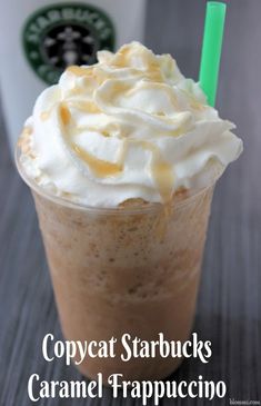 a close up of a drink with whipped cream on top and a green straw in the cup