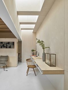 a room that has some chairs and a table in it with a skylight on the ceiling