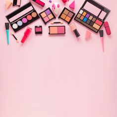 various makeup products arranged on a pink background