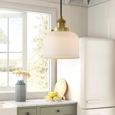 a white refrigerator freezer sitting inside of a kitchen next to a sink and window