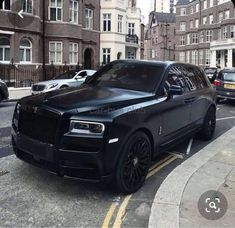 a black rolls royce parked on the side of a street