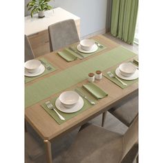 the table is set with plates and silverware, along with green napkins on it