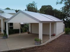 a white house with two garages in front of it