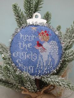 a cross stitch ornament hanging from a tree