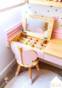 a wooden desk with a mirror and pink chair