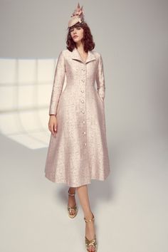 This iconic Hunter Coat Dress silhouette takes inspiration from a vintage hunting coat and is cut from our beautiful blush pink and burnished gold Italian jacquard cloth containing wool and silk. The tailored bodice nips in the waist and features an open collar and a high back neck pitch, as well as a flattering, fluid, semi-circular skirt with side seam pockets. The coat is fully lined in silk. High ball covered buttons add a beautiful feature as well as a secure fastening, giving you the confi Elegant A-line Outerwear For Party, Elegant A-line Outerwear For Formal Events, Elegant A-line Outerwear For Formal Occasions, Elegant A-line Party Outerwear, Elegant Pink Silk Outerwear, Elegant Jacquard Semi-formal Outerwear, Fitted Pink Brocade Dress, Elegant Single Breasted Jacquard Outerwear, Elegant Brocade Outerwear For Formal Occasions