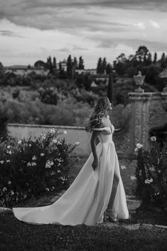 black and white photo of woman in wedding dress looking off to the side with flowers