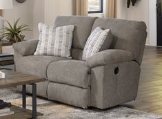 a living room scene with focus on the reclining sofa and two accent pillow cases