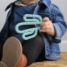 a toddler sitting on the floor holding a pair of scissors