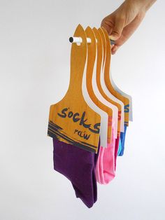 a person holding six pairs of socks in one hand and the other with five different colors