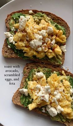 two pieces of bread with eggs and cheese on them, sitting on a white plate