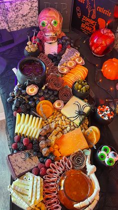 a table topped with lots of different types of halloween foods and candys on top of it