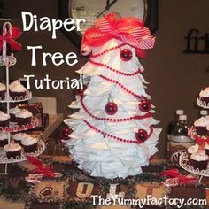 a christmas tree made out of cupcakes on a table with the words diaper tree