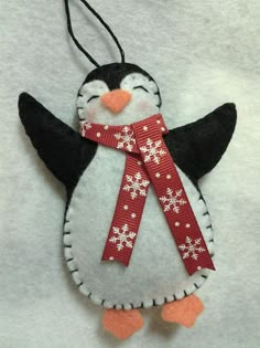 a penguin ornament with a red scarf around its neck