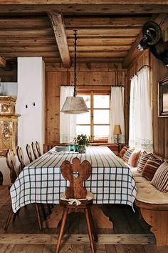 a dining room table with a teddy bear on it and some chairs in front of the table