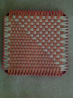 an orange and white woven placemat on a green surface